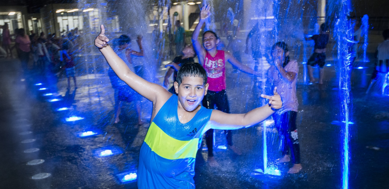 Niños disfrutando durante la noche en los chorros de agua de UVA Aguas Claras