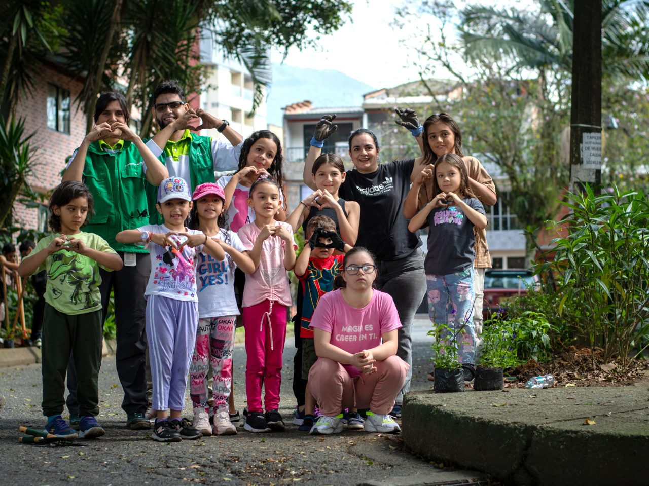 Colaboradores de Fundación Grupo EPM y niños posando para foto haciendo gestos de corazón
