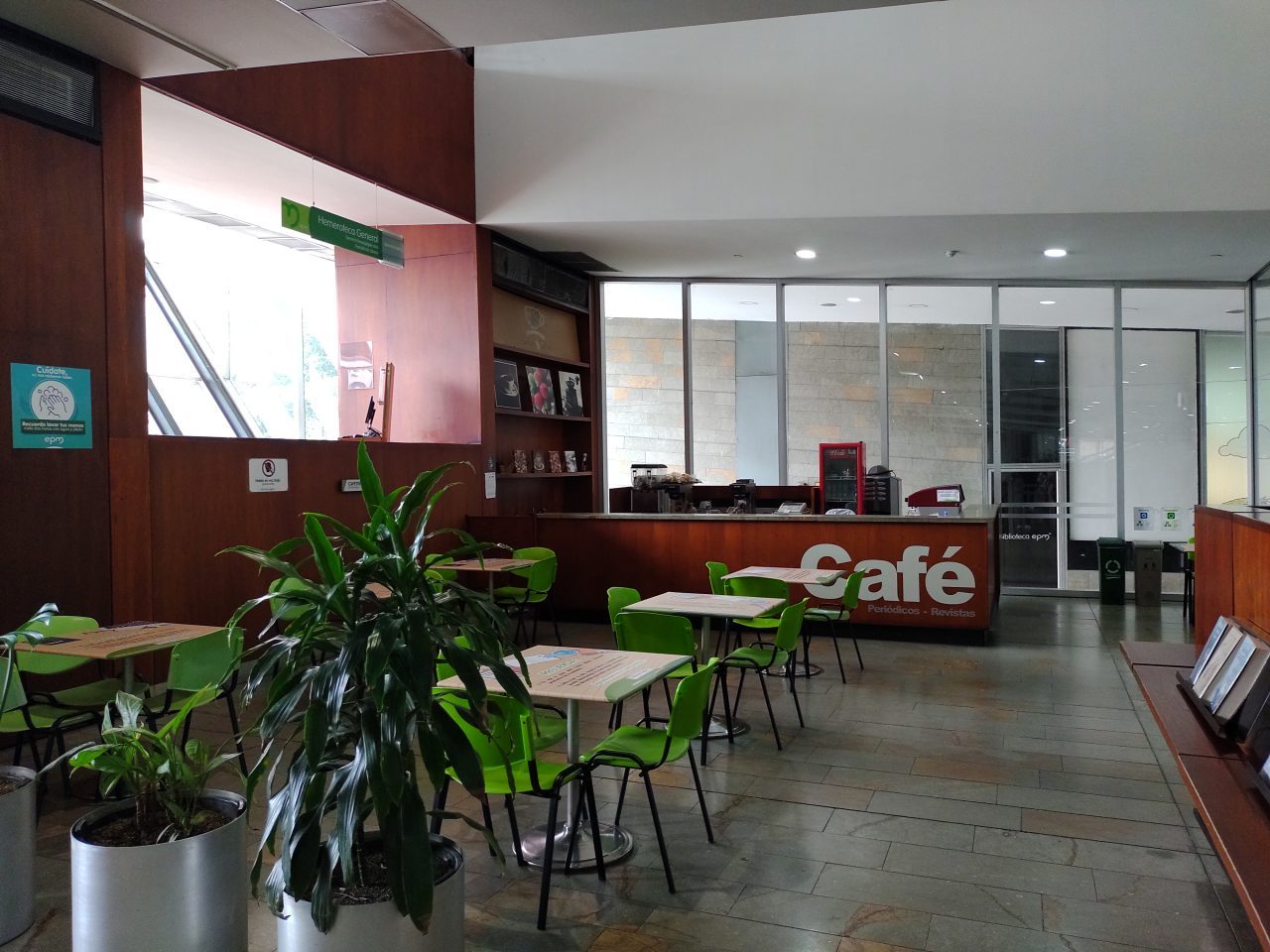 Sillas dentro de la biblioteca, mesas y una nevera