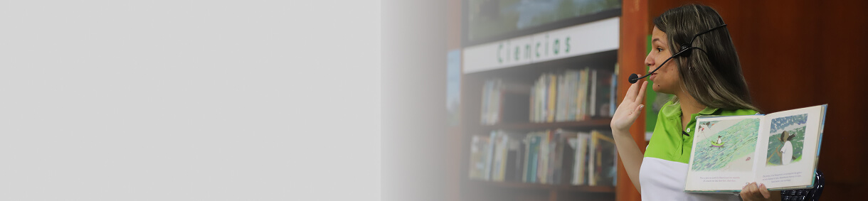 Fotografía de una mujer leyendo un libro al interior de la Biblioteca EPM