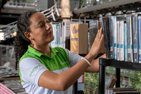 Fotografía de una mujer buscando un libro en la Biblioteca EPM