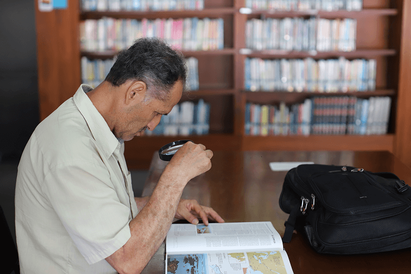 Fotografía de un señor leyendo un libro en la Biblioteca EPM