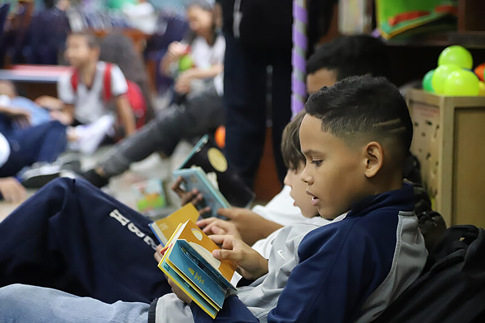 Fotografía de un niño leyendo un libro en la Biblioteca EPM