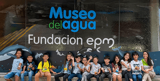 Fotografía de un grupo de niños sentados afuera del Museo del Agua EPM