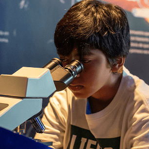 Niño viendo a través de un microscopio 