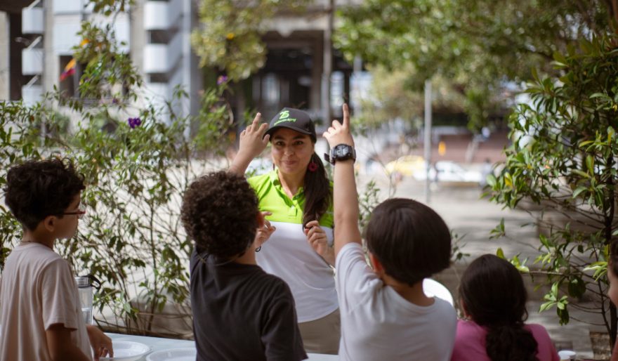 Niños levantando la mano a funcionaria