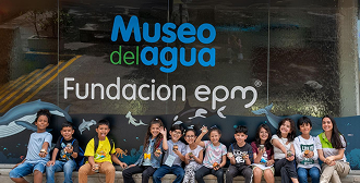 Fotografía de un grupo de niños sentados afuera del Museo del Agua EPM