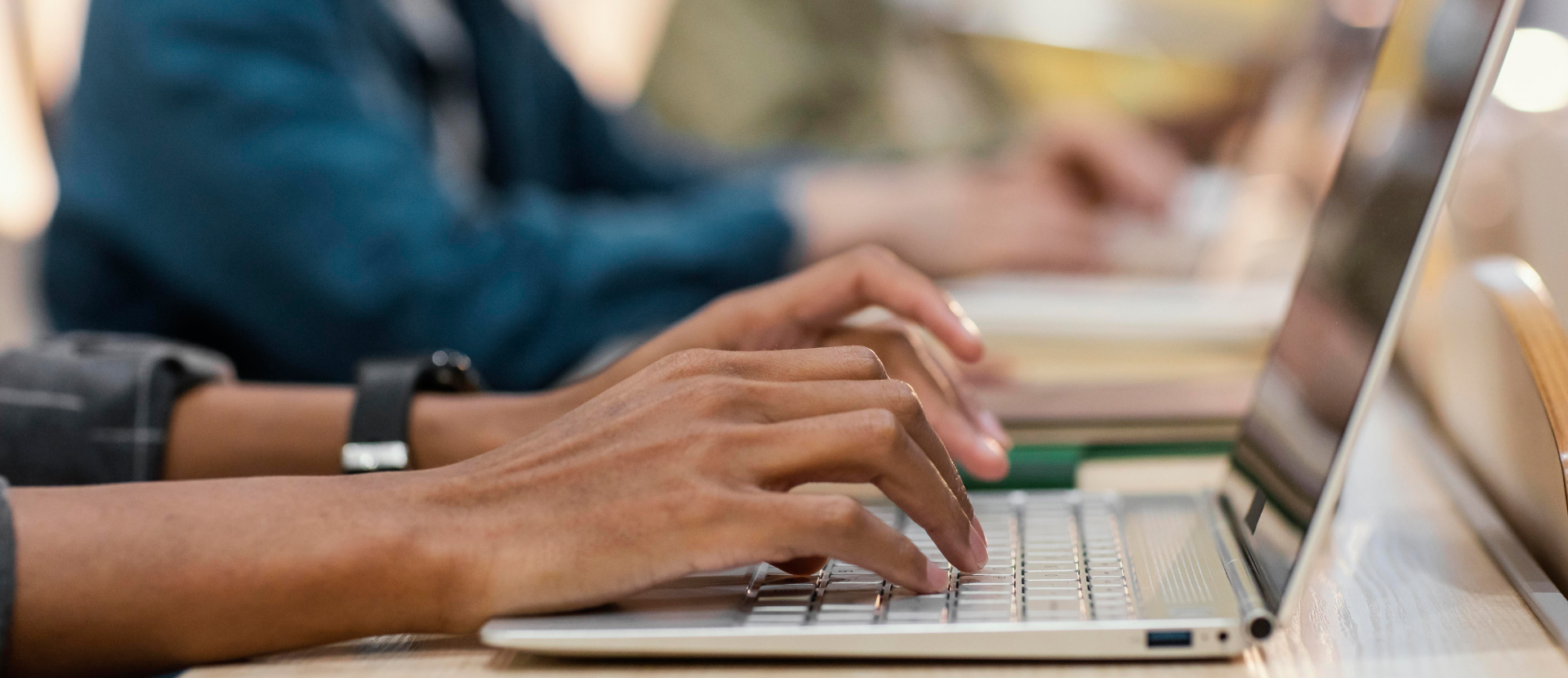 Se muestran manos de una persona escribiendo en un pc portátil 