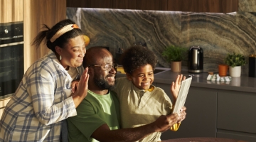 Familia sonriendo frente a un dispositivo electrónico