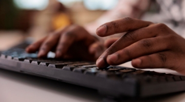 Manos escribiendo en un teclado de computador
