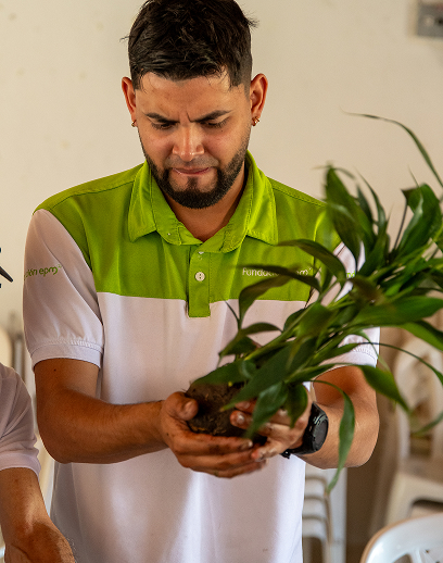 Colaborador de Fundación Grupo EPM sosteniendo una planta en sus manos