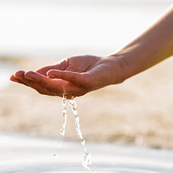 Imagen de una mano recogiendo agua
