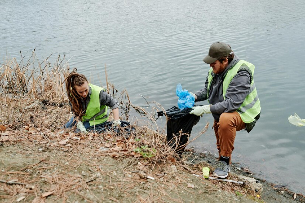 Personas recogiendo basura cerca de un rio
